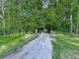 Gravel driveway leading to a private home surrounded by dense trees and greenery at 4422 Fincher Rd, Canton, GA 30114