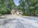 Traditional home with attached two-car garage and covered porch surrounded by lush trees at 4422 Fincher Rd, Canton, GA 30114