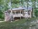 Charming home with a inviting front porch surrounded by mature trees on a sloped lawn at 4422 Fincher Rd, Canton, GA 30114