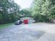 Outbuilding with three garage doors with vehicles and equipment parked nearby at 4422 Fincher Rd, Canton, GA 30114