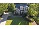 Aerial view of a stately home with gray siding, lush lawn, and a curved driveway surrounded by trees at 1037 Creek Side Dr, Canton, GA 30115