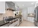 Stylish kitchen showcasing stainless steel oven, stove, and hood with tiled backsplash, granite countertops, and white cabinets at 167 Freyer Ne Dr, Marietta, GA 30060