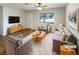 Bright living room with modern furnishings, stylish rug, a ceiling fan, and a large window offering natural light at 407 Old Towne Cir, Lawrenceville, GA 30046