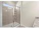 Modern bathroom featuring a tiled shower with glass doors and shelving for optimal organization at 2569 Village Park Bnd, Duluth, GA 30096