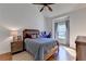 A well-lit bedroom with hardwood floors, a ceiling fan, and a large window at 5760 Windjammer Pt, Cumming, GA 30041