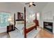 Luxurious bedroom featuring a four-poster bed, fireplace, and large windows overlooking the trees at 5760 Windjammer Pt, Cumming, GA 30041