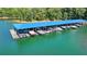 Aerial view of a large, covered boat dock with numerous boat slips along the lake shore at 5760 Windjammer Pt, Cumming, GA 30041