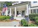 Inviting front porch features classic columns, a welcoming seating area, and manicured landscaping at 5760 Windjammer Pt, Cumming, GA 30041