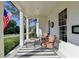 Charming front porch with seating area, black and white striped rug, and American flag at 5760 Windjammer Pt, Cumming, GA 30041