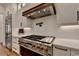 Gourmet kitchen with stainless steel range, custom vent hood, white cabinets, and designer backsplash at 5760 Windjammer Pt, Cumming, GA 30041