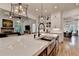 Stylish kitchen with island and stainless sink, with a view of living and dining areas at 5760 Windjammer Pt, Cumming, GA 30041