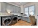 Well-organized laundry room featuring gray cabinets, modern washer and dryer and white countertops by window at 5760 Windjammer Pt, Cumming, GA 30041