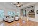 Comfortable sitting area with plush armchairs and ottomans next to stairs, under a ceiling fan at 5760 Windjammer Pt, Cumming, GA 30041