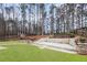 Expansive backyard featuring a stone terrace, patio, and lush green artificial turf at 9811 Spyglass Dr, Villa Rica, GA 30180