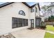 Back exterior of a light-colored home featuring dark-trimmed windows, a door, and a small outdoor patio area at 9811 Spyglass Dr, Villa Rica, GA 30180