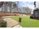 Lush backyard featuring a stone patio, terraced landscaping, and a wooden deck at 9811 Spyglass Dr, Villa Rica, GA 30180