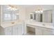 Bright bathroom with dual vanities, white cabinetry, gold hardware, and large mirrors at 9811 Spyglass Dr, Villa Rica, GA 30180