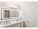 Bathroom featuring double sinks, marble countertops, and a large, illuminated mirror with modern light fixture at 9811 Spyglass Dr, Villa Rica, GA 30180