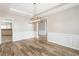 Spacious dining room with modern chandelier and wainscoting is open to the kitchen at 9811 Spyglass Dr, Villa Rica, GA 30180