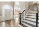 Inviting foyer featuring hardwood floors, staircase, and arched doorway at 9811 Spyglass Dr, Villa Rica, GA 30180