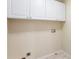 A laundry room with white cabinets above the hookups for the washing machine and dryer at 9811 Spyglass Dr, Villa Rica, GA 30180