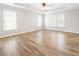 Bright main bedroom featuring laminate floors, ceiling fan, and three windows at 9811 Spyglass Dr, Villa Rica, GA 30180