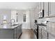 Modern kitchen with gray cabinets, stainless steel appliances, granite countertops, and hardwood floors at 3897 Lockaby Way, Lawrenceville, GA 30044