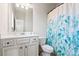 Bathroom with a vanity, toilet, and a shower with a blue and green patterned curtain at 238 Gallant Fox Way, Acworth, GA 30102