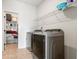 Laundry room with two new stainless steel washing machines and dryer, with storage shelf and rack at 238 Gallant Fox Way, Acworth, GA 30102