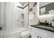 Modern bathroom featuring marble tiles, a shower-tub combo, and a stylish granite vanity at 662 S Grand Nw Ave, Atlanta, GA 30318