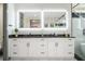 Bathroom showcasing double vanity with modern lights, black countertop, sleek fixtures and white cabinets at 662 S Grand Nw Ave, Atlanta, GA 30318