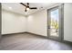 Bedroom with light gray floors and a door leading to a balcony overlooking trees at 662 S Grand Nw Ave, Atlanta, GA 30318