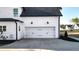 A two-car garage featuring carriage-style doors, exterior lighting, and a smooth concrete driveway at 71 Presley Farm Ln, Rockmart, GA 30153