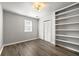 Bright bedroom with a built-in bookshelf, closet with louvered doors, and a window with natural light at 1031 Steeple Run, Lawrenceville, GA 30043