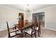 Dining room with classic table set, stylish light fixture, and view to living area at 1031 Steeple Run, Lawrenceville, GA 30043