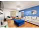 Bright living room with hardwood floors, blue accent wall, and a comfortable gray sofa at 1031 Steeple Run, Lawrenceville, GA 30043