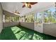 Bright sunroom with artificial grass, ceiling fans, and windows offering views of the surrounding greenery at 1031 Steeple Run, Lawrenceville, GA 30043