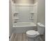 Clean bathroom features a tub-shower combination with built-in shelving, complemented by a standard toilet at 1055 Pinecrest Dr, Forest Park, GA 30297