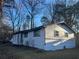 This home has white siding, black trim, and large trees in the front yard at 1055 Pinecrest Dr, Forest Park, GA 30297