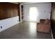 Bright living room featuring wood paneling, built-in shelves, and tile flooring at 6441 Holiday Blvd, Forest Park, GA 30297