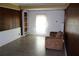 Bright living room featuring wood paneling, built-in shelves, and tile flooring at 6441 Holiday Blvd, Forest Park, GA 30297