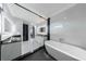 Modern bathroom with a soaking tub, glass shower, and sleek black and white design at 676 S Grand Nw Ave, Atlanta, GA 30318