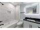 Updated bathroom featuring marble tile, black hardware, and a modern vanity with an LED mirror at 676 S Grand Nw Ave, Atlanta, GA 30318