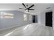 Spacious room with light wood floors, three windows, and ceiling fan at 676 S Grand Nw Ave, Atlanta, GA 30318