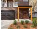 Modern two-story home with dark wood siding, red door, and well-manicured landscaping at 676 S Grand Nw Ave, Atlanta, GA 30318