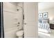 Bathroom featuring a white shower-tub combo and toilet next to an open bedroom doorway at 1141 Burlington Ct, Mcdonough, GA 30253