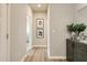 Bright hallway with wood floors, decorative art, and a stylish side table at 1141 Burlington Ct, Mcdonough, GA 30253
