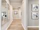 Long hallway with light wood floors and modern artwork on the walls at 1141 Burlington Ct, Mcdonough, GA 30253