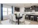 Kitchen and dining area with dark brown cabinets, island, and white dining chairs at 1141 Burlington Ct, Mcdonough, GA 30253
