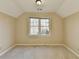 Bedroom with beige walls and carpet flooring, with a window letting in natural light at 711 Providence Dr, Lawrenceville, GA 30044